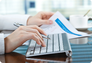 Professional reviewing financial documents, typing on keyboard. Ideal for 10-Q & 10-K Filing preparation
