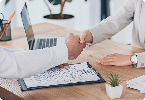 Two business people shake hands over a contract, symbolizing a deal or investment agreement like reg cf funding